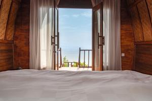 a bedroom with a bed and a view of the ocean at Sea Cliff Eco Nusa Penida in Polilit