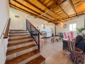 a living room with a staircase and a kitchen at GuestReady - El Pinar isla del Hierro in El Pinar del Hierro