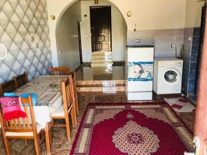 a kitchen with a table and a washing machine at Nubian house in Jazīrat Salūjah