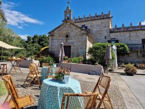 a patio with tables and chairs in front of a building at Hotel Pazo O Rial in Vilagarcia de Arousa