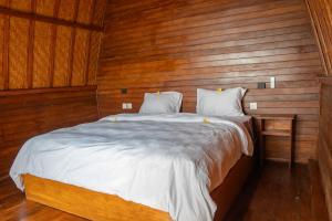 a bedroom with a large bed with wooden walls at Sea Cliff Eco Nusa Penida in Polilit +21 photos