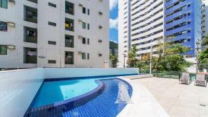 a swimming pool in front of a building at Flat in Boa Viagem leisure great location PM805 in Recife