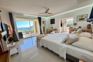 a bedroom with a large bed and a balcony at Villa Grand Baie in Agay - Saint Raphael