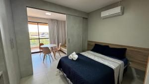 a bedroom with a bed and a table and a window at Flats e apartamentos Eco resort Praia dos Carneiros in Tamandaré +287 photos