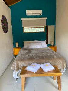 a bedroom with a large bed with two white towels at Chales Sao Felix in São Bento do Sapucaí
