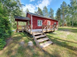 a red cabin with a staircase leading to it at Fishing and holiday village Merikoivula in Uusikaupunki