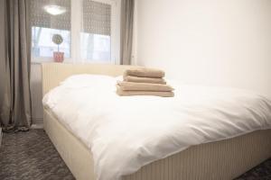 a white bed with towels on top of it at Tina Home in Cluj-Napoca