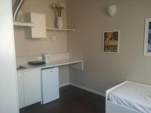 a small kitchen with a white counter and a bed at B&B Leonardo in Rho