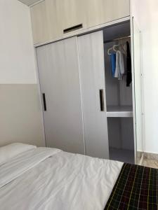 a bedroom with a white bed and a closet at Cornerstone Suites in Āīzawl