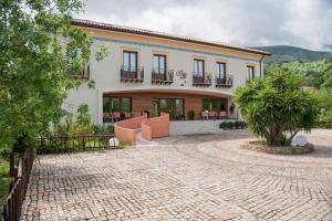 a large house with a patio and a courtyard at Alle Querce Hotel Ristorante in Castelbuono