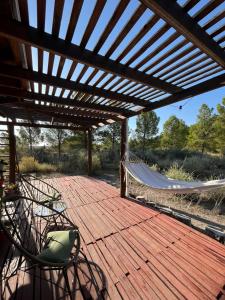 a hammock on a wooden deck with a hammock at Cabaña Viedma in Viedma