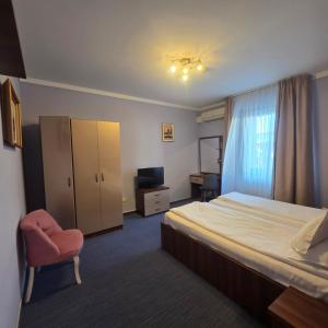 a hotel room with a bed and a chair at Conacul Domnesc in Suceava