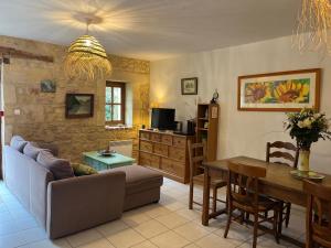 a living room with a couch and a table at La Riviere Esperance in Veyrignac