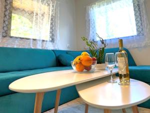 a table with a bowl of oranges and a bottle of wine at Guest House Julia in Stavros