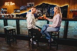 a man and a woman sitting at a bar at Hotel SKI in Belá