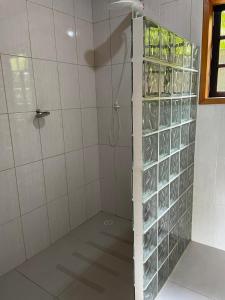 a shower with a glass block wall in a bathroom at Chales Sao Felix in São Bento do Sapucaí +59 photos