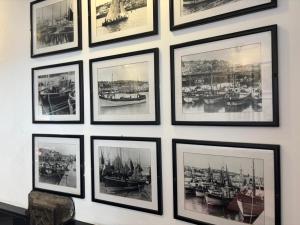 a group of framed photos of boats on a wall at The Swordfish Inn in Penzance