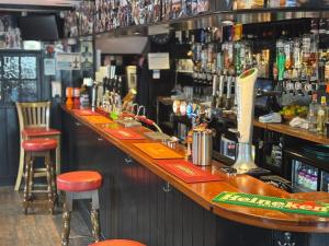 a bar with orange stools at a bar at The Swordfish Inn in Penzance
