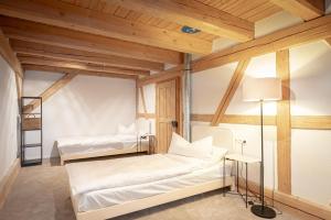 two beds in a room with wooden ceilings at tobel 1853 apartments in Leutkirch im Allgäu