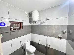 a bathroom with a white toilet and a window at Bloom Fort Villa in Kannur +40 photos
