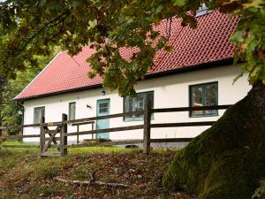 a white house with a red roof and a fence at Fiskarhuset - seaside cottage 4 pax in Sjöbo