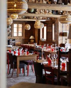 a restaurant with wooden tables and chairs and chandeliers at Hotel Le Portillo in Val Thorens