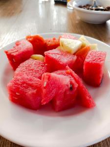 a plate of watermelon and other fruits on a table at M2 Homestay Berastagi in Berastagi