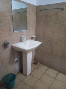 a bathroom with a white sink and a mirror at BG Guest House Jaffna in Tirunelveli East