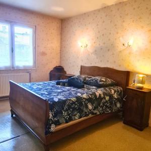 a bedroom with a large bed with a blue comforter at Vintage House in Ambérieu-en-Bugey
