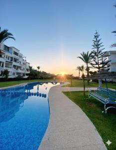 a swimming pool with a bench next to a building at Ray CaboNegro Sea & Pool View in Cabo Negro