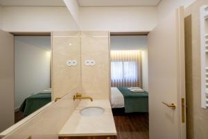 a bathroom with a sink with a mirror at Music Apartment II in Bicas