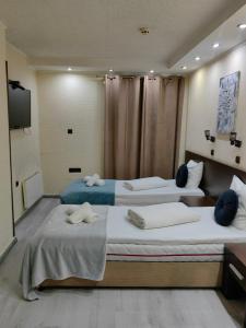 two beds in a hotel room with towels on them at Hostel By the Hill in Veliko Tŭrnovo