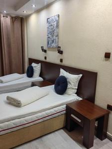 a room with two beds and a table in it at Hostel By the Hill in Veliko Tŭrnovo