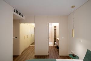 a bedroom with white walls and a room with a bed at Music Apartment II in Bicas