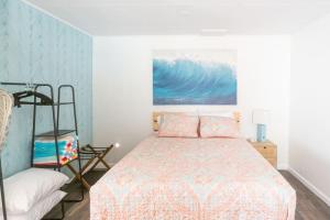 a bedroom with a bed and a painting on the wall at Beachside Bungalow steps from sand in San Diego