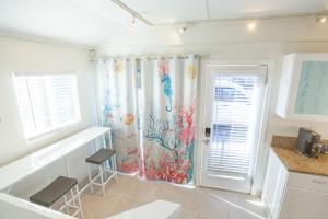 a kitchen with a shower curtain with an aquarium at Beachside Bungalow steps from sand in San Diego +17 photos