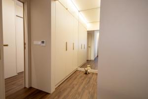 a hallway with white cabinets and a teddy bear on the floor at Music Apartment II in Bicas