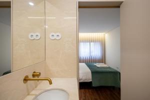 a bathroom with a shower with a toilet and a bed at Music Apartment II in Bicas +31 photos