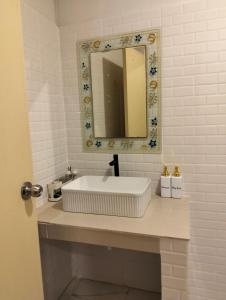 a bathroom with a white sink and a mirror at Koh jum Mutu Home Stay in Ban Ko Phrao