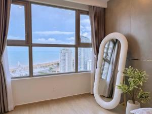 a room with a mirror and a large window at The Sóng Vung Tau Apartment - Pool Near Sea in Vung Tau