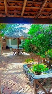 a patio with a picnic table and an umbrella at BELL MAR CHALéS 01e 02 in Luis Correia
