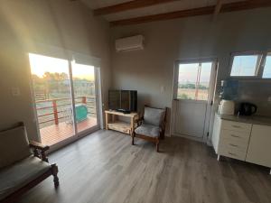 a room with a chair and a desk and windows at Cabaña Flor Tandil in Tandil
