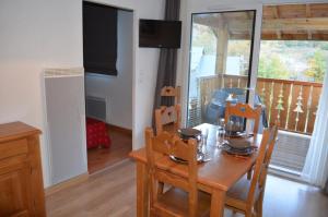 a dining room with a table and chairs and a balcony at Les Reflets d'Ax in Ax-les-Thermes