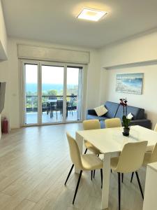 a living room with a table and chairs and a couch at Bergeggi Sea View Apartment - Torre del Mare in Bergeggi
