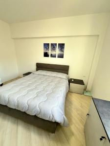 a bedroom with a large bed with two pictures on the wall at Bergeggi Sea View Apartment - Torre del Mare in Bergeggi