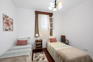 a small room with two beds and a window at Violeta House in Funchal