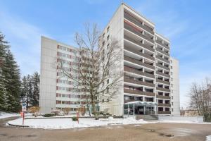 a tall building in front of a parking lot at Ramoni Apartments - NaturTraum Kniebis in Freudenstadt