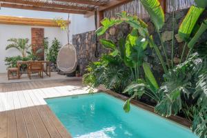 a swimming pool in a tropical garden with a swing at BaliHouse by Aura Collection in La Oliva