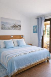 a bedroom with a large bed with blue sheets at Blue Bay Apartment in Cala Bitta +78 photos