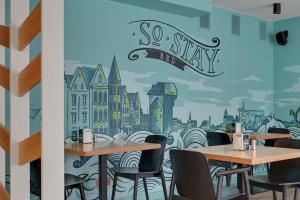 a restaurant with tables and chairs and a mural of a city at So Stay Bed & Breakfast - Self Check-in in Gdańsk